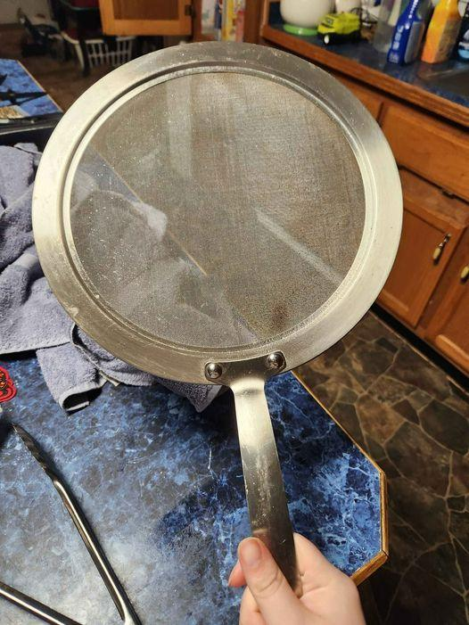 Found in a storage space with several pots and pans, a circular metal piece that includes a fine mesh screen